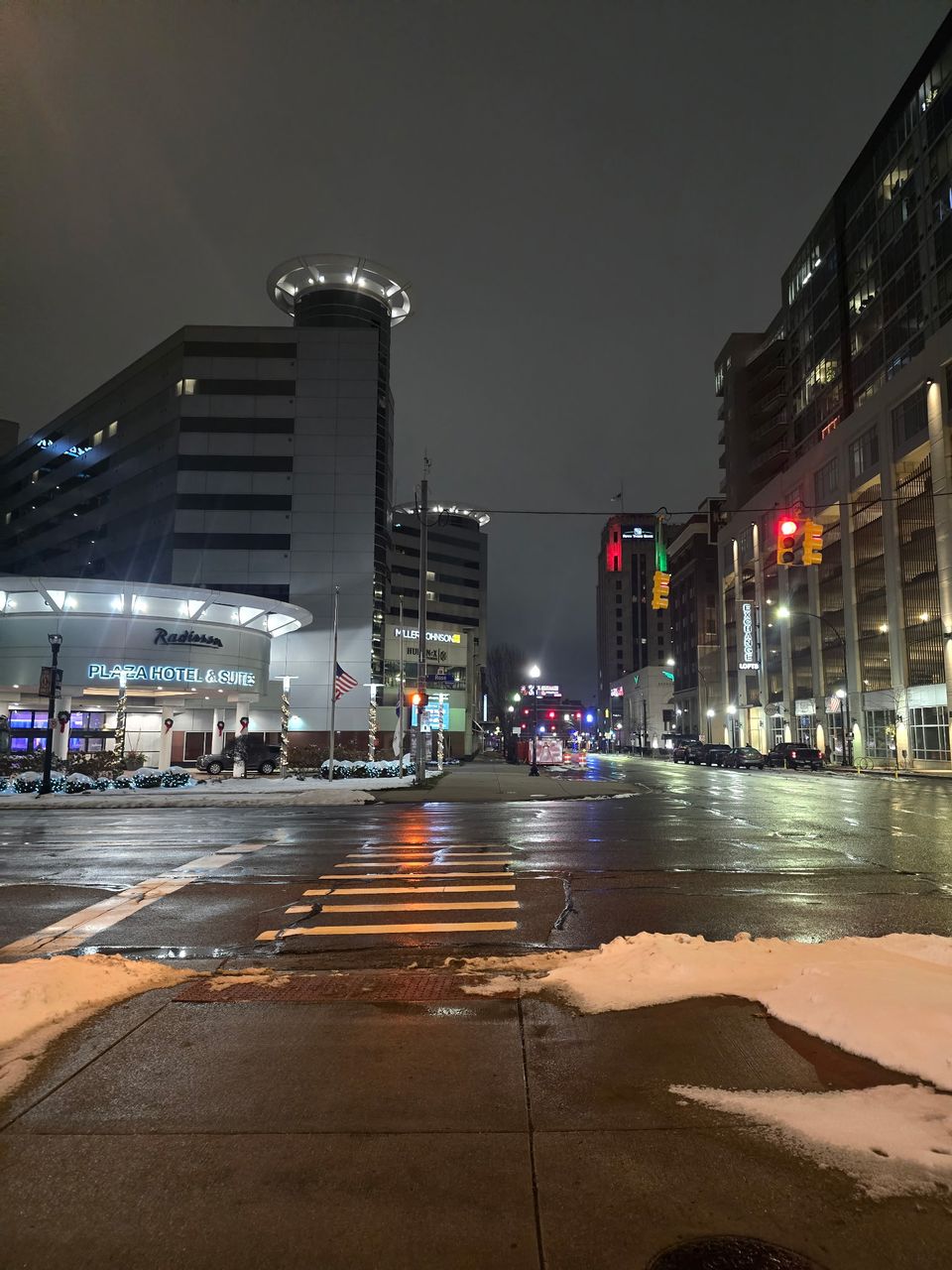 Downtown Kalamazoo at night, with city lights reflected on the street.